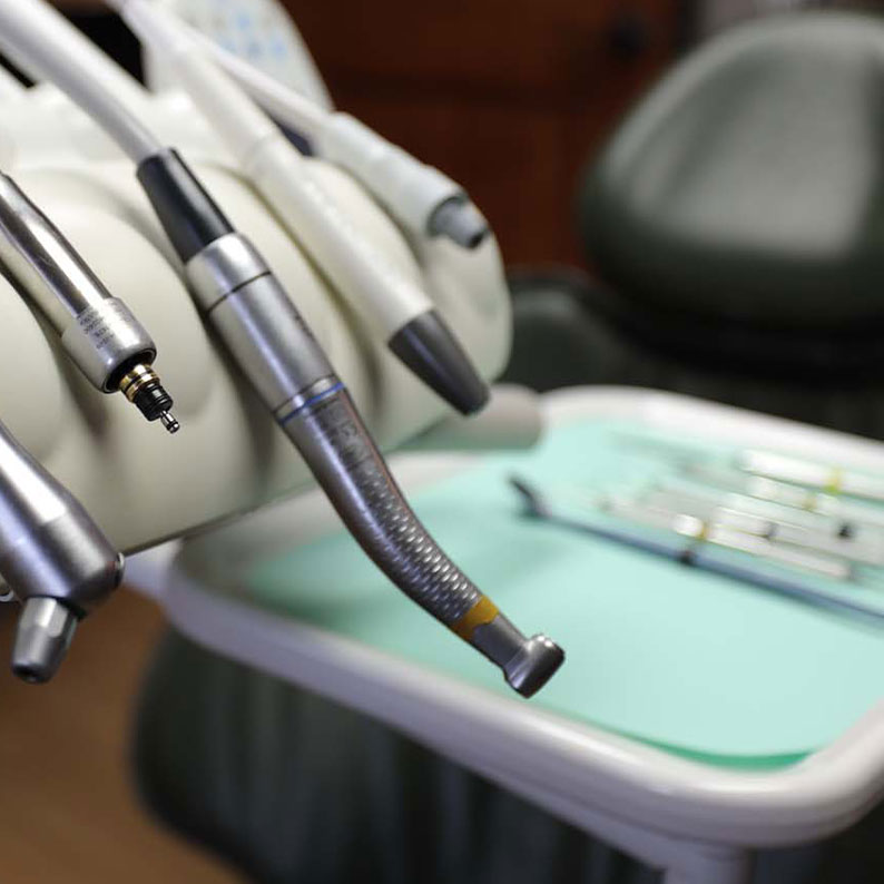 Dental tools and handpieces on a treatment tray