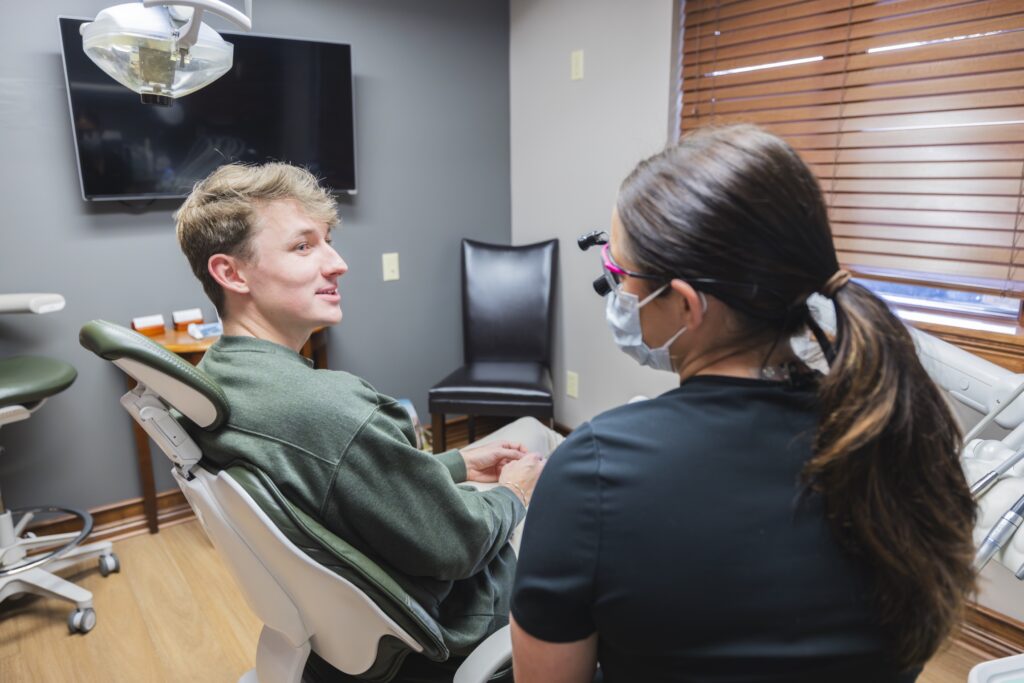 Dentist discussing dental care with patient seated in exam chair