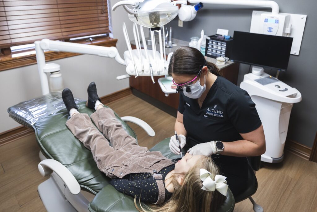 Dental hygienist performing routine cleaning for young patient